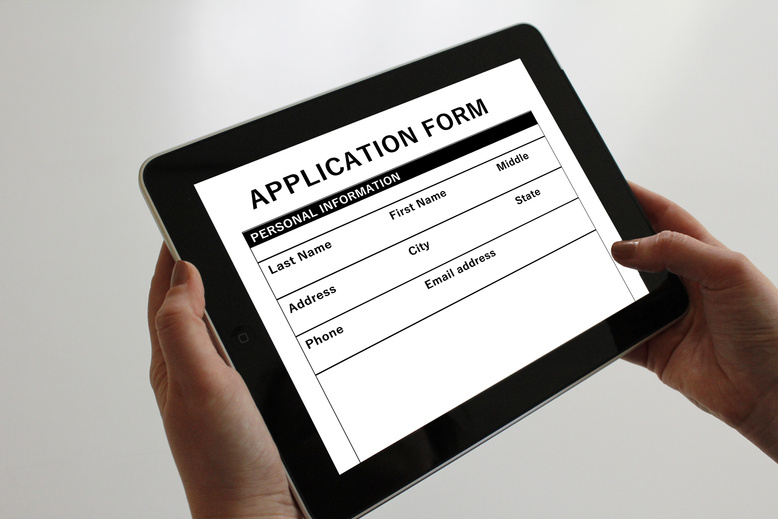 Hands Holding Tablet With Application Form